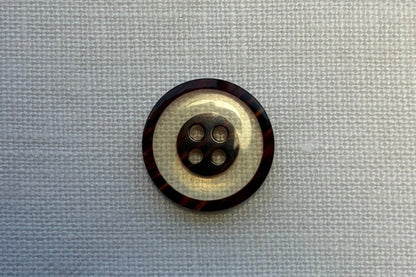 Brown and white button on a white fabric background