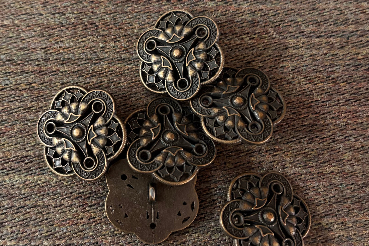 Bronze decorative buttons on a textured brown surface
