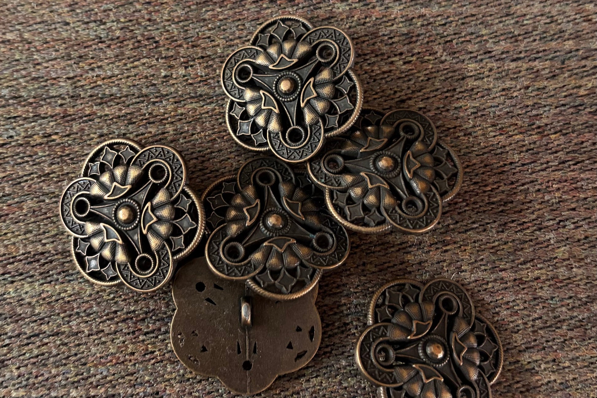 Bronze decorative buttons on a textured brown surface