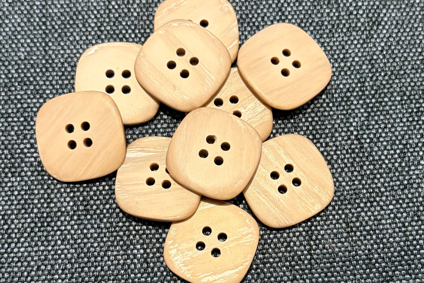 Tan buttons on a gray fabric background