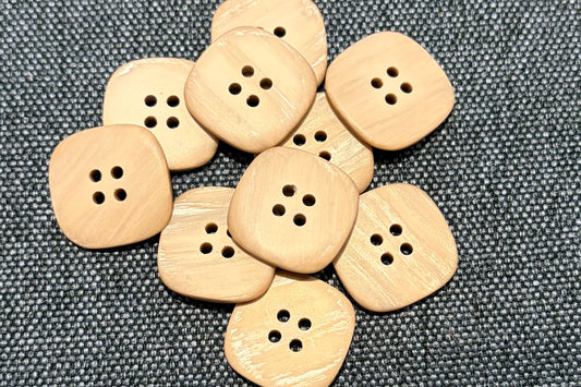 Tan buttons on a gray fabric background
