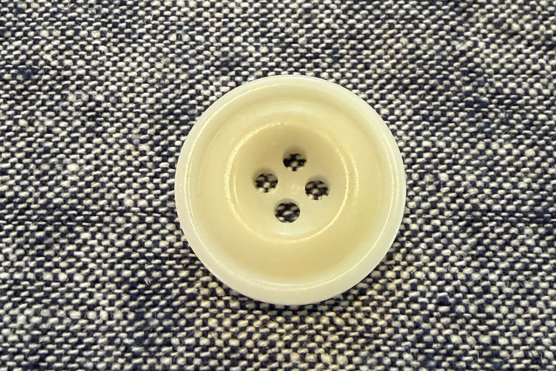 White button on a textured gray fabric background