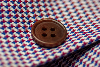 Close-up of a button on a red, white, and blue checkered fabric