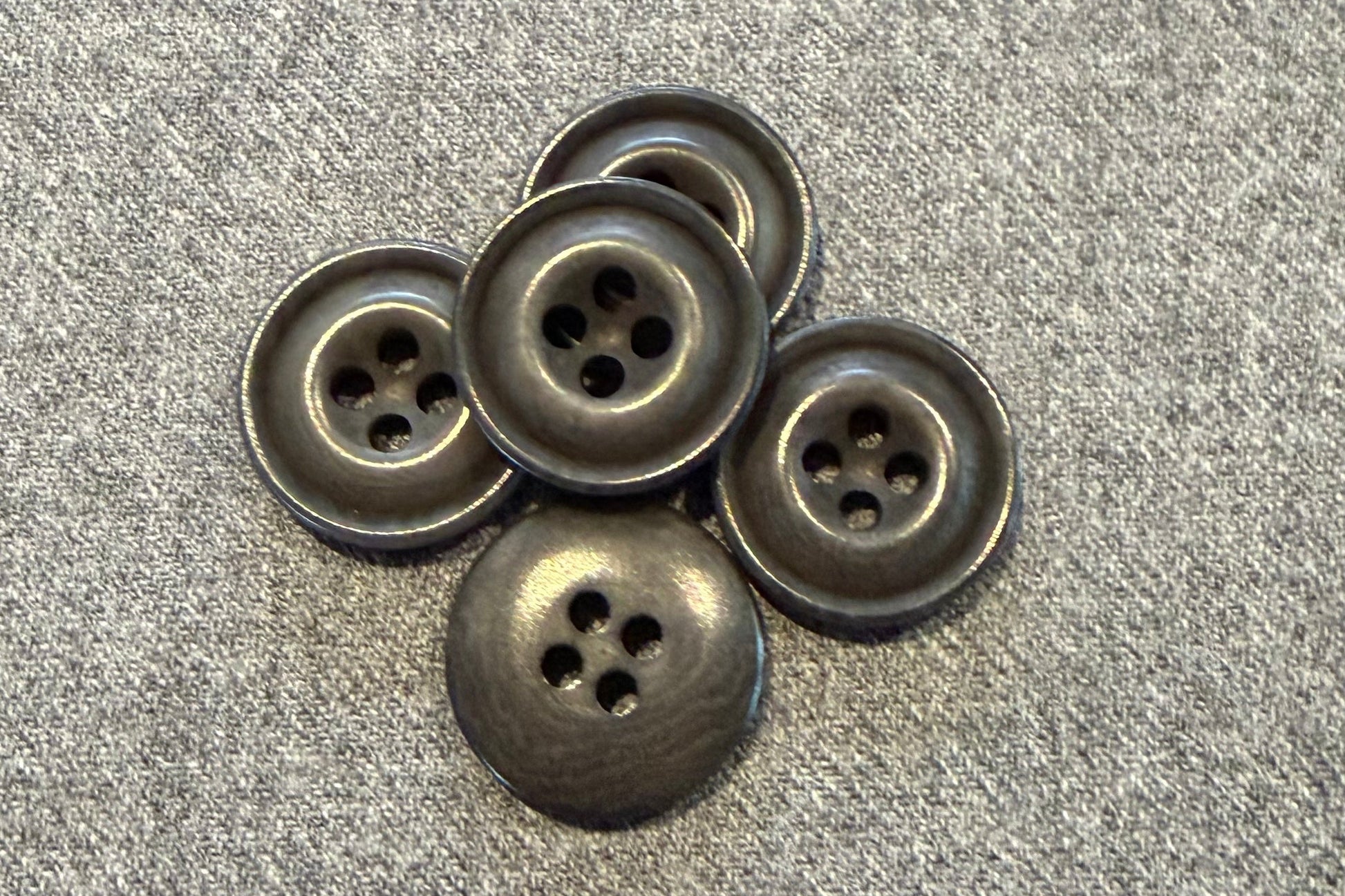 Five grey buttons on a textured gray surface
