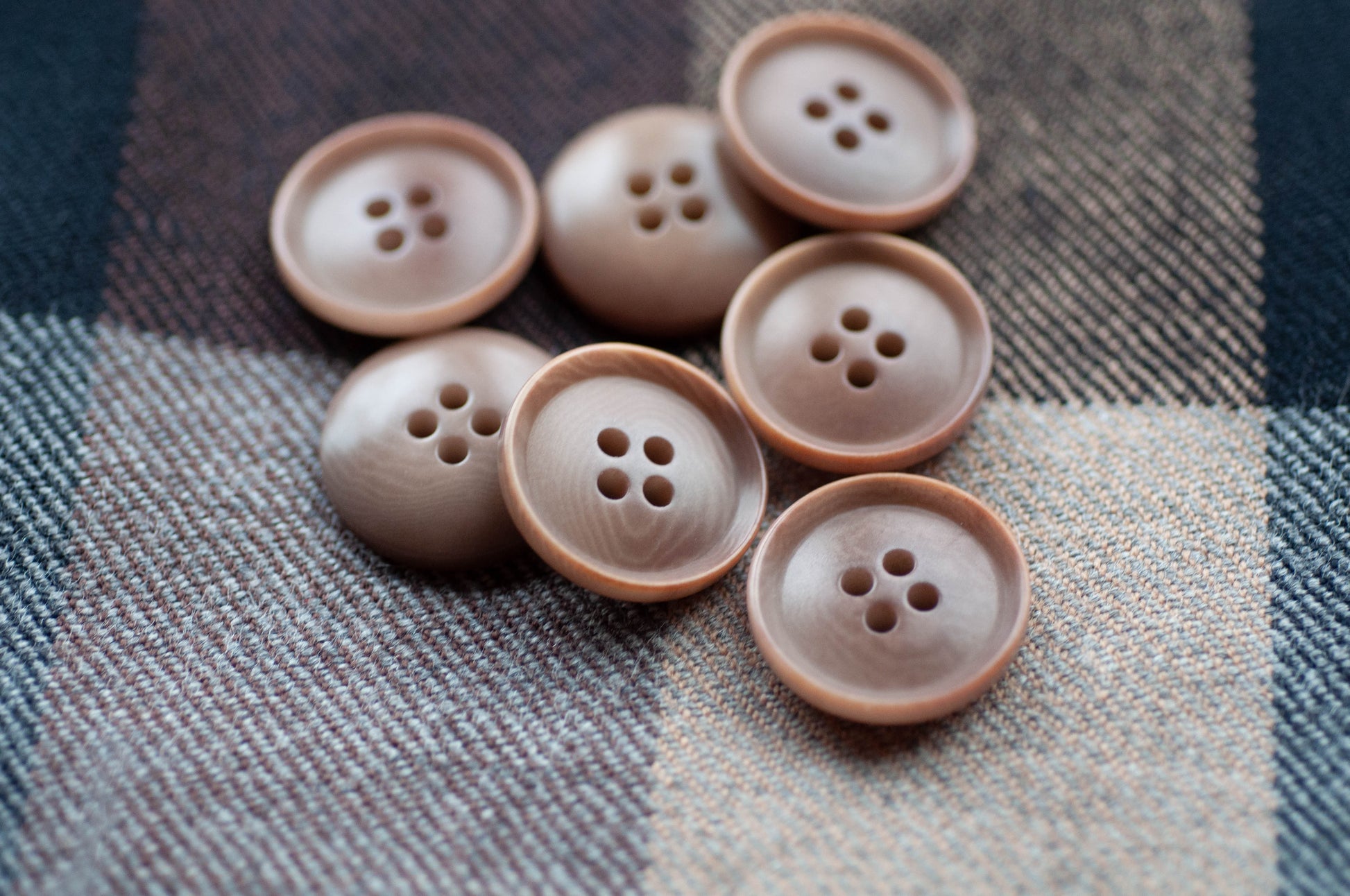 Brown buttons on a plaid fabric background