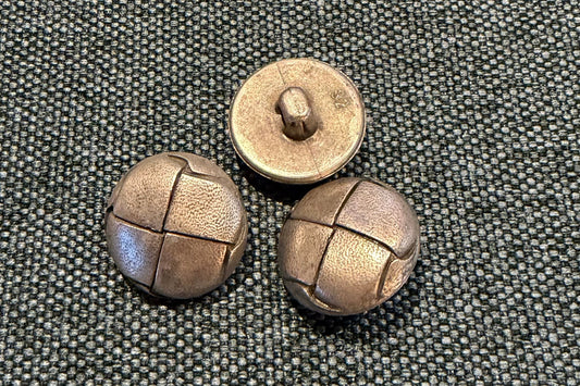 Three silver-coloured buttons on a textured gray surface