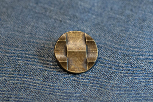 Bronze button on a denim fabric background