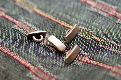 Close-up of metal buttons on a textured fabric background